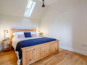 a bedroom with a wooden bed with blue sheets at 1 Bed in Alness oc-83888 in Alness