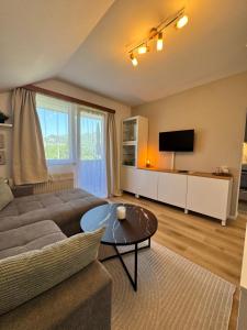 a living room with a couch and a table at Ferienwohnung Edeltraud, fußläufig zum See und 20 Minuten vom Skigebiet entfernt in Döbriach
