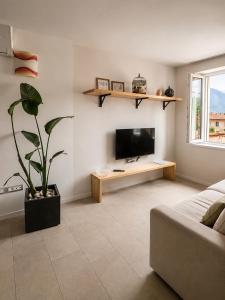 a living room with a flat screen tv and a couch at ES Apartments in Nago-Torbole