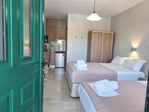 a hotel room with two beds and a kitchen at George Studios in Vasiliki