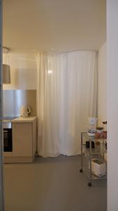 a kitchen with a white curtain in a room at Orphé37, grand appartement cocon au cœur de la Gascogne artistique in Lectoure