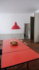a red table with a bowl of fruit on it at Orphé37, grand appartement cocon au cœur de la Gascogne artistique in Lectoure +8 photos
