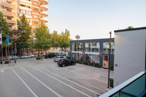 a parking lot with a car parked in front of a building at Laid Hotel in Vlorë