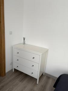 a white dresser in a bedroom with a white wall at Piękna Góra House in Gołdap