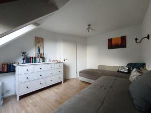 a living room with a couch and a white dresser at Harbour Apartment in Moos +13 photos