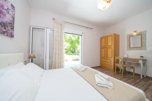 a bedroom with a bed and a desk and a window at Orchid Garden Apartment in Sami