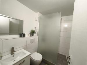 a white bathroom with a toilet and a sink at Harbour Apartment in Moos
