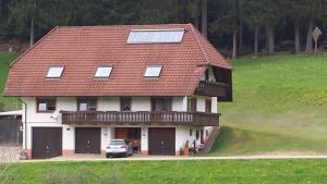 a house with a roof with a car parked in front at Ferienwohnung Ringwald in Biederbach Baden-Württemberg