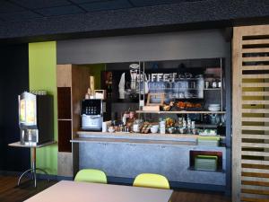 a view of a kitchen with a counter in a restaurant at Hotel ibis Budget Laval in Bonchamp-lès-Laval