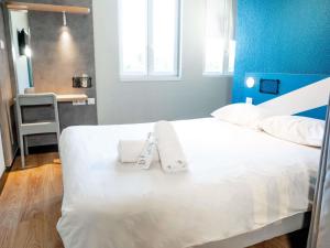 a bedroom with a bed with towels on it at ibis budget Aix en Provence in Aix-en-Provence +64 photos