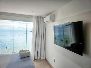 a bedroom with a large view of the ocean at Sofia's on the Beach in Búzios