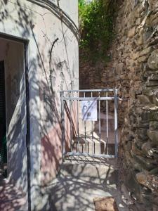 a metal gate on a stone building with a door at Manarola Sunset House in Manarola