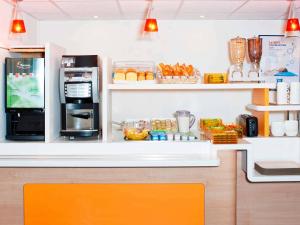 a kitchen with a counter with a refrigerator and some food at ibis budget Amberieu en Bugey/Chateau Gaillard A42 in Château-Gaillard