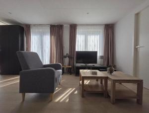 a living room with a couch and a chair and a table at Robin's oak lodge in Epe