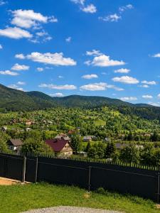 a view of a town from a fence with mountains in the background at Panorama Hrytsulivka in Vorokhta