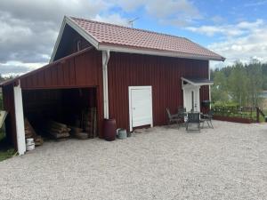 a red barn with a white door and a table at Gästhus Nittsjö in Rättvik