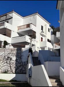 a white building with stairs in front of it at Cozy Aegean Escape in Skopelos Town