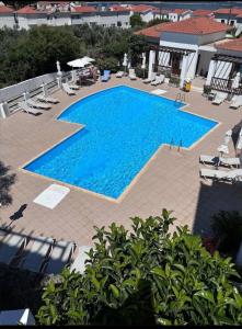 an overhead view of a large swimming pool with chairs at Cozy Aegean Escape in Skopelos Town
