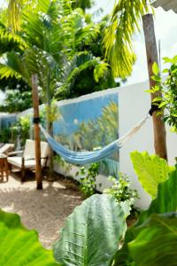a hammock in the middle of a garden with plants at Tamu House Paje in Paje