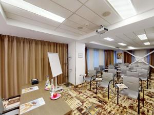 a room with rows of chairs and tables in it at Mercure Bucharest City Center in Bucharest