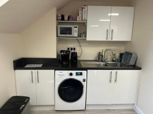 a kitchen with a washing machine and a sink at Quiet studio flat near University & QMC, King size bed in Nottingham