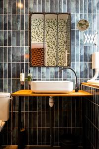 a bathroom with a sink and a mirror at Nouvel Hôtel & Appartements in Oyonnax +129 photos