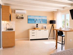 a kitchen with white cabinets and a table at ES Apartments in Nago-Torbole