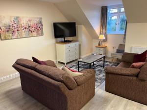 a living room with two couches and a flat screen tv at Quiet studio flat near University & QMC, King size bed in Nottingham
