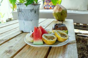 a plate of fruit on a wooden table at Tamu House Paje in Paje