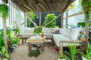 a patio with a white couch and a table at Tamu House Paje in Paje +30 photos