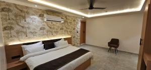 a bedroom with a bed and a chair in it at Velara Hotel & Banquet in Gwalior +10 photos