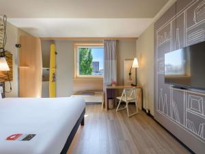 a hotel room with a bed and a tv at Ibis München City Arnulfpark in Munich