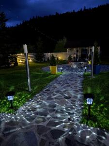 a stone walkway at night with lights in the grass at Pensiunea Crescent Predeal in Predeal +28 photos