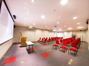 a conference room with red chairs and a projection screen at ibis Imperatriz in Imperatriz