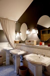 a bathroom with two sinks and two mirrors at Captain Whidbey in Coupeville