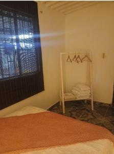 a bedroom with a bed and a mirror and a window at Cachipay panche in Cachipay