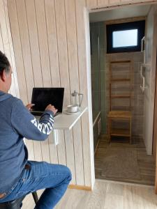 a man sitting at a table with a laptop at Tiny House con Vista al Mar, ideal para Teletrabajo o Descanso en Pichilemu in Pichilemu