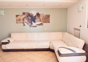 ein Wohnzimmer mit einer Couch und zwei Gemälden an der Wand in der Unterkunft Milele B&B in Somma Lombardo + 35 Fotos
