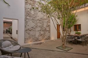 a room with a table and chairs and a tree at Casa Carmen Morelos in Oaxaca City