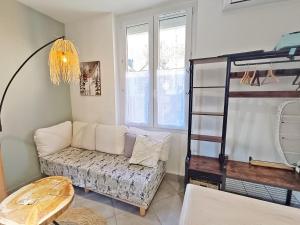 a living room with a couch and a bunk bed at La coulée verte - superbe duplex climatisé - jardin - classé 3 étoiles in Luchon