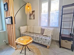 a living room with a couch and a table at La coulée verte - superbe duplex climatisé - jardin - classé 3 étoiles in Luchon