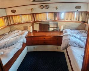 a bedroom with two beds and a desk with a mirror at bateau nuit insolite in Carentan