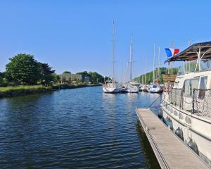 a group of boats are docked in a river at bateau nuit insolite in Carentan