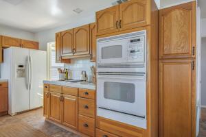 a kitchen with wooden cabinets and white appliances at Welcome To Riverside - Spacious, Cozy, Central in Riverside