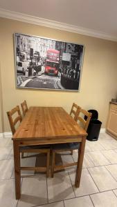 a wooden table with chairs and a red double decker bus at Spacious comfy stay in Richmond