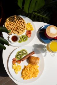two white plates of breakfast food on a table at Hotel Boutique Obelisco in Medellín