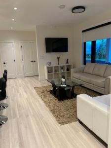 a living room with a couch and a table at Luxury EW Bed & Breakfast in Abbotsford