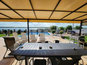 eine Terrasse mit Tisch und Stühlen und ein Pool in der Unterkunft CasaMari in Corbu