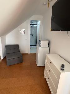 ein kleines Wohnzimmer mit einem Sessel und einem Kühlschrank in der Unterkunft CasaMari in Corbu