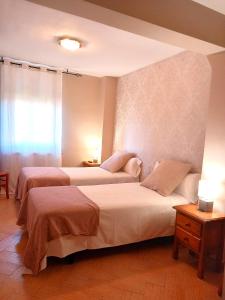 a hotel room with two beds and a window at HOTEL RURAL ORQUIDEA in Velilla del Río Carrión